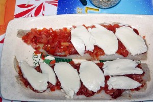 Der Fisch wird danach mit den Tomatenwürfeln und anschließend mit den Mozarellascheiben belegt.
