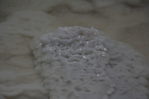 Weiß glitzert das Salz auf den Ufersteinen. Teilweise ist es auch kompaktes Salz ohne Steinfüllung.